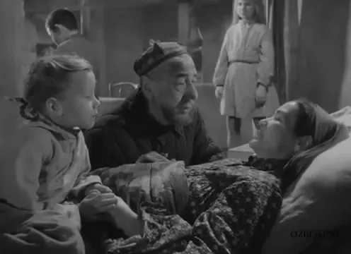 Yatakta uzanan kadının yanında bir yetişkin ve çocuklar bulunuyor. Sen Yetim Emassan (1962).