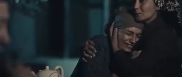 Ağlayan bir kadın başını ona sarılan kadına yaslıyor. Ilhaq (2020).
